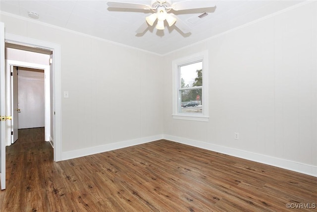 empty room featuring ceiling fan, dark wood-type flooring, and ornamental molding