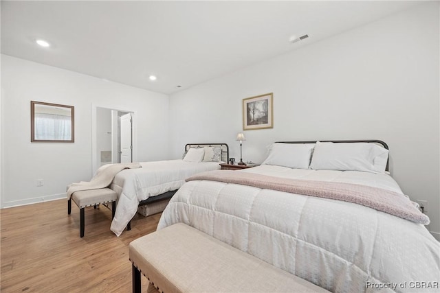 bedroom featuring ensuite bathroom and light hardwood / wood-style floors