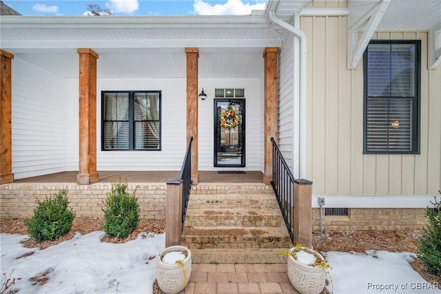 view of exterior entry featuring covered porch