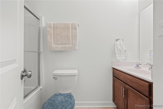 full bathroom featuring toilet, enclosed tub / shower combo, and vanity