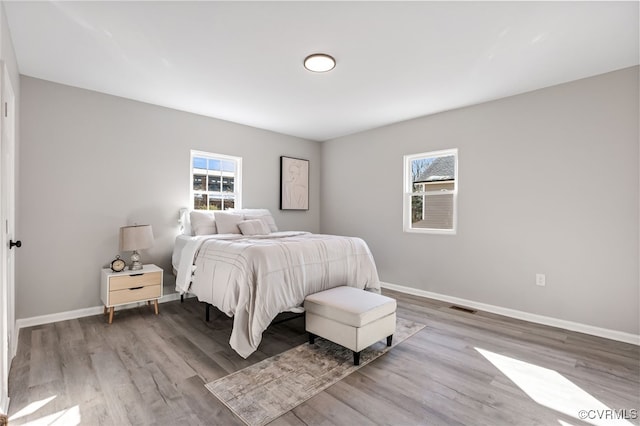 bedroom featuring hardwood / wood-style flooring and multiple windows