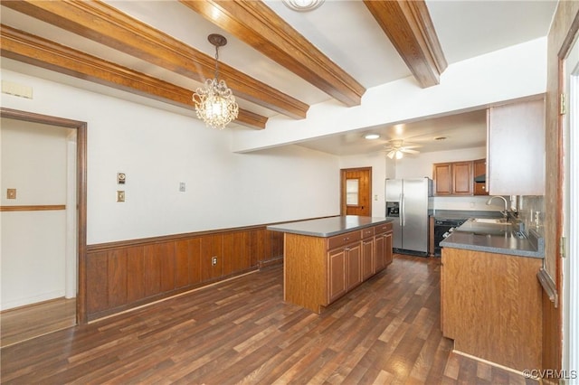 kitchen with dark wood-type flooring, a center island, stainless steel fridge with ice dispenser, decorative light fixtures, and beamed ceiling