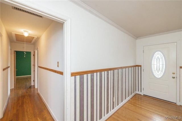 foyer entrance with wood-type flooring and crown molding