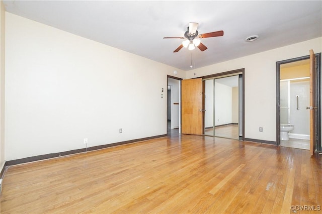 unfurnished bedroom featuring light hardwood / wood-style flooring, a closet, ceiling fan, and ensuite bathroom