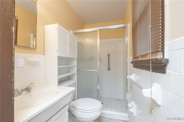 bathroom featuring vanity, toilet, tile walls, and walk in shower