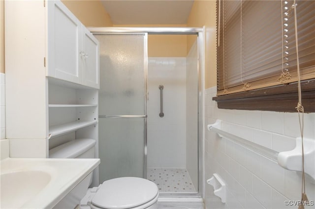 bathroom featuring tile walls, toilet, and walk in shower