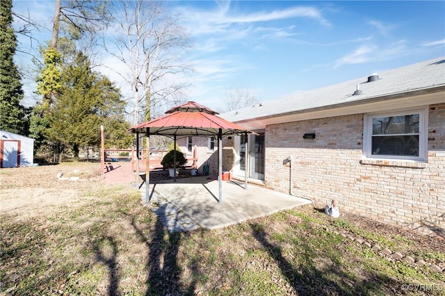 view of yard featuring a gazebo, a patio area, and a storage unit