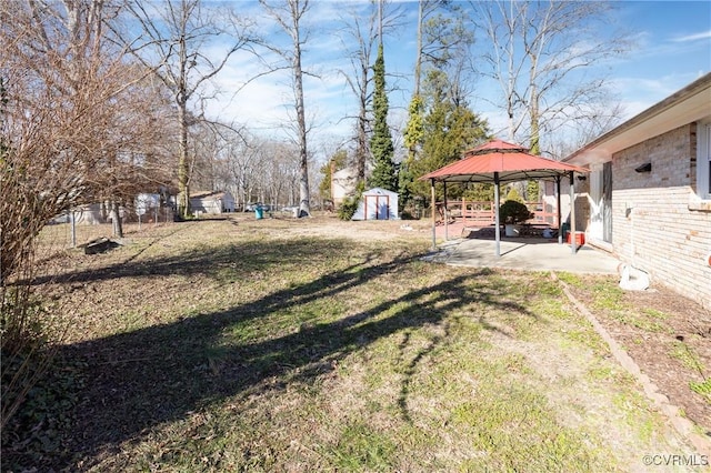 view of yard with a gazebo, a patio area, and a storage shed