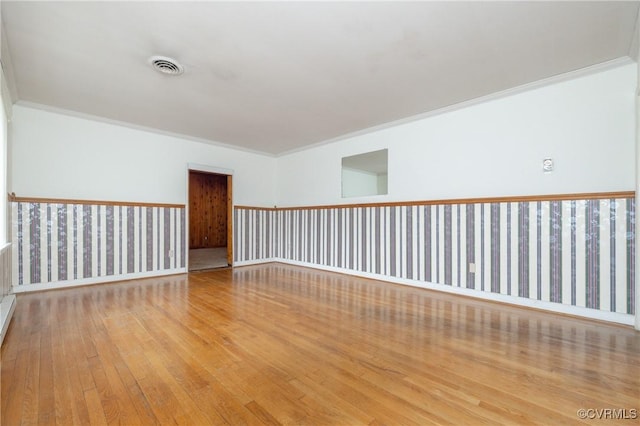 spare room with ornamental molding and light hardwood / wood-style floors