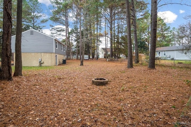 view of yard featuring cooling unit and an outdoor fire pit