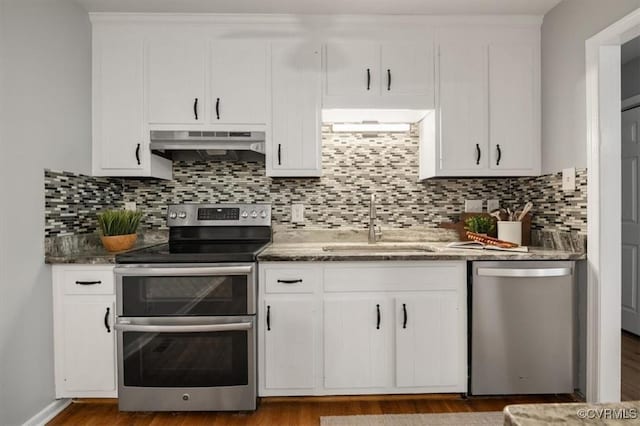 kitchen with stainless steel appliances, decorative backsplash, white cabinets, and sink