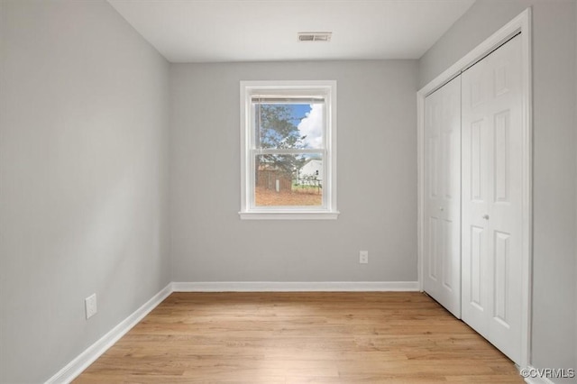 unfurnished bedroom with a closet and light hardwood / wood-style flooring