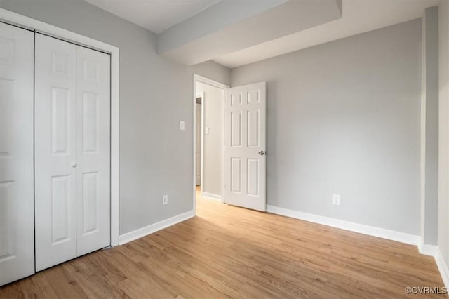 unfurnished bedroom with a closet and light hardwood / wood-style floors