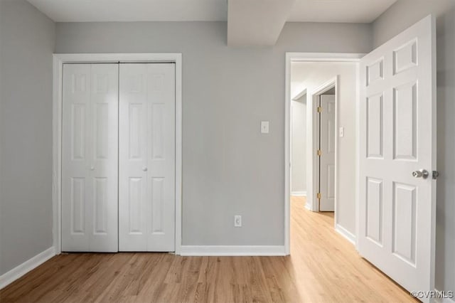 unfurnished bedroom featuring a closet and light hardwood / wood-style floors