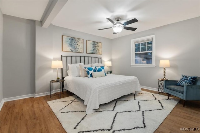 bedroom featuring beam ceiling, ceiling fan, and hardwood / wood-style floors