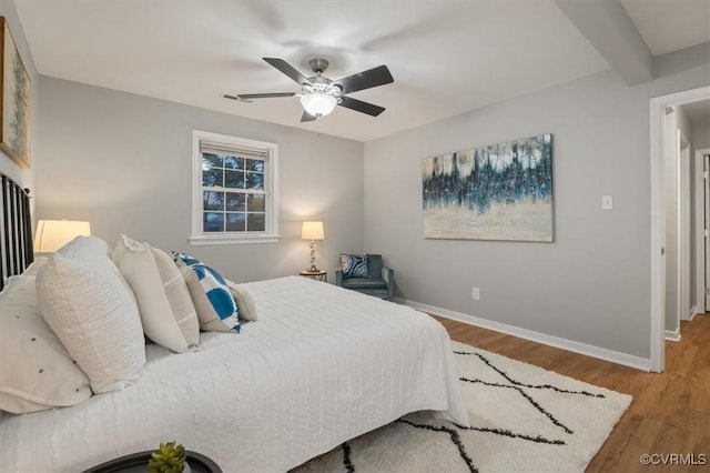 bedroom with ceiling fan, wood-type flooring, and beamed ceiling