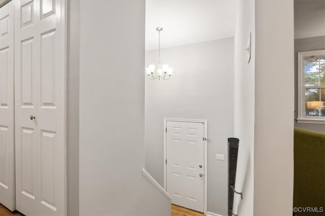 corridor with a notable chandelier and hardwood / wood-style flooring