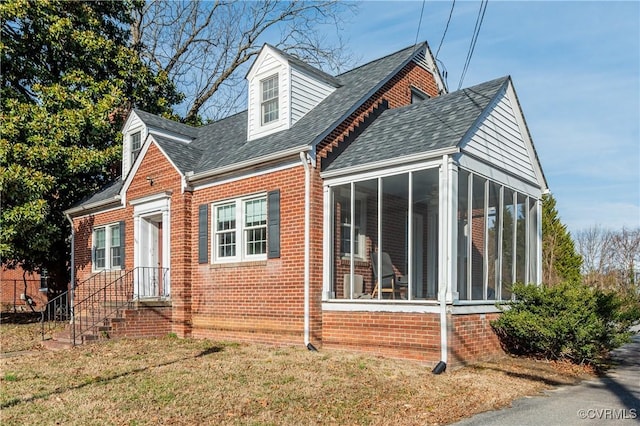 view of front of house featuring a front lawn and a sunroom