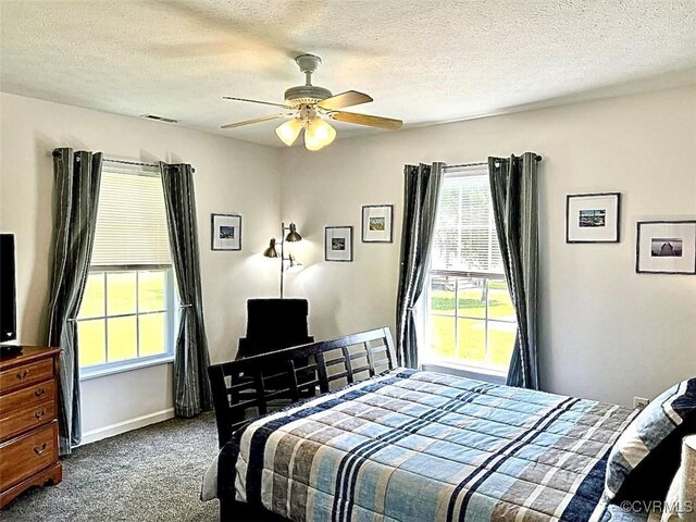 bedroom with ceiling fan, a textured ceiling, and dark carpet