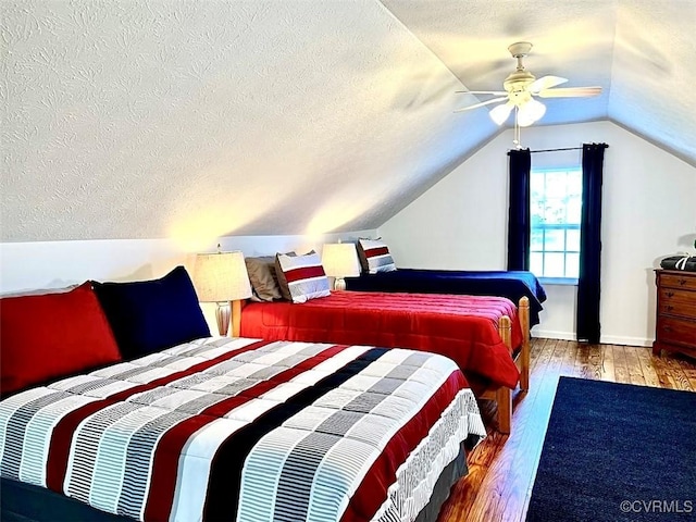 bedroom featuring ceiling fan, lofted ceiling, hardwood / wood-style floors, and a textured ceiling