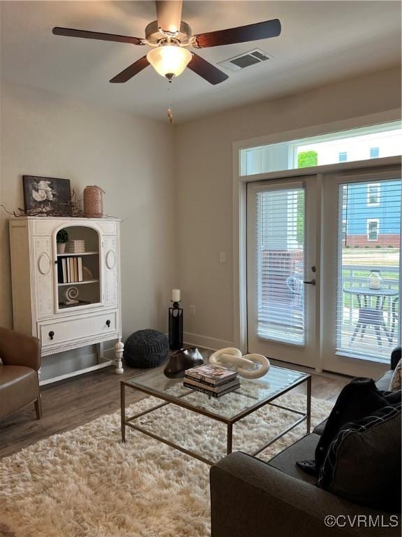 living room featuring ceiling fan, wood-type flooring, french doors, and a healthy amount of sunlight