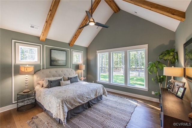 bedroom with ceiling fan, dark wood-type flooring, and beam ceiling