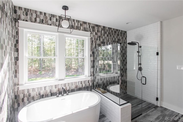 bathroom featuring wood-type flooring, tile walls, and separate shower and tub