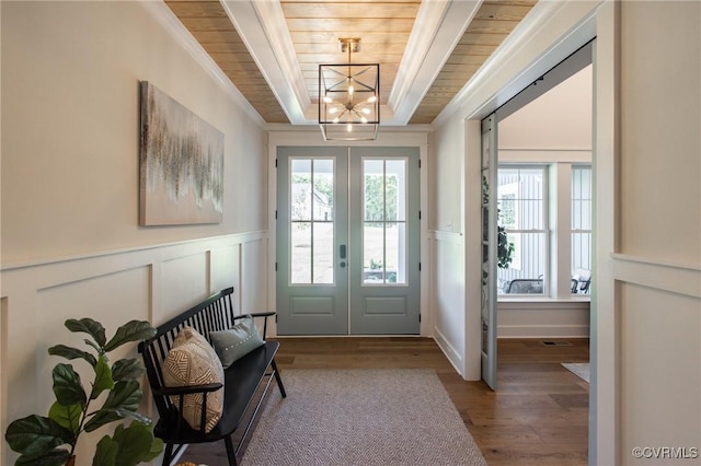 doorway to outside featuring hardwood / wood-style floors, wooden ceiling, a notable chandelier, french doors, and ornamental molding