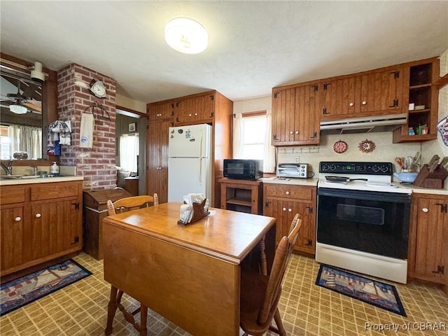 kitchen with ceiling fan, white refrigerator, range with electric cooktop, and sink