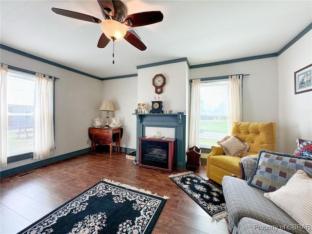 living room featuring dark wood-type flooring, crown molding, and ceiling fan