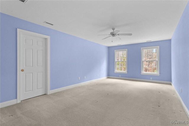 carpeted spare room featuring ceiling fan