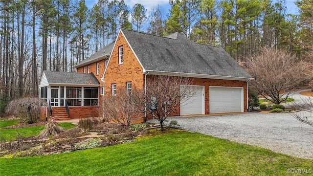 view of front facade with a front yard, a garage, and a sunroom