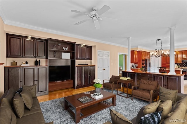 living room with decorative columns, light hardwood / wood-style floors, ornamental molding, and ceiling fan with notable chandelier