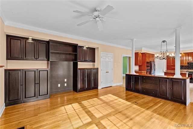 kitchen featuring light hardwood / wood-style floors, decorative columns, decorative light fixtures, crown molding, and ceiling fan with notable chandelier