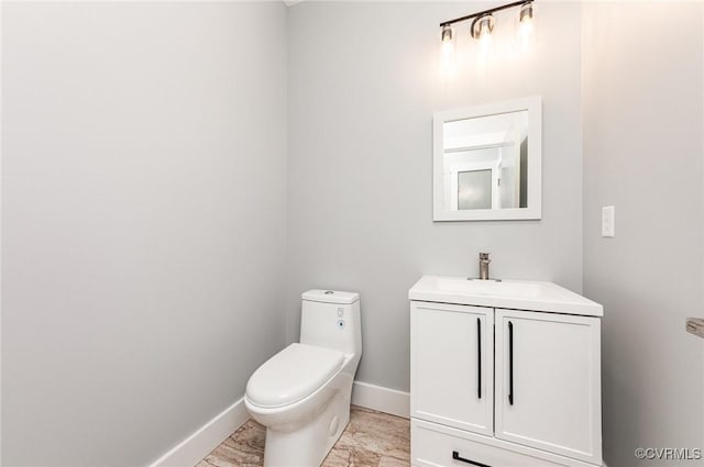 bathroom with vanity, marble finish floor, baseboards, and toilet