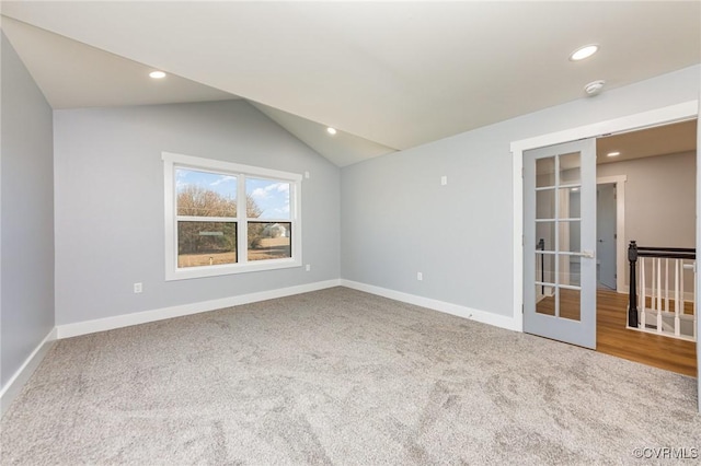 spare room featuring baseboards, lofted ceiling, french doors, and carpet