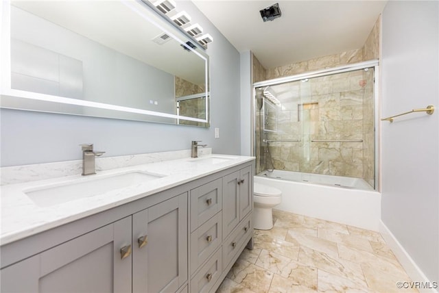 full bathroom with combined bath / shower with glass door, a sink, double vanity, and toilet