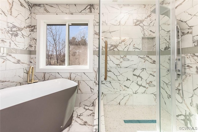 bathroom featuring marble finish floor, a freestanding tub, and a marble finish shower