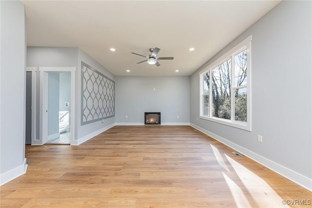 unfurnished living room with light wood finished floors, baseboards, recessed lighting, and ceiling fan