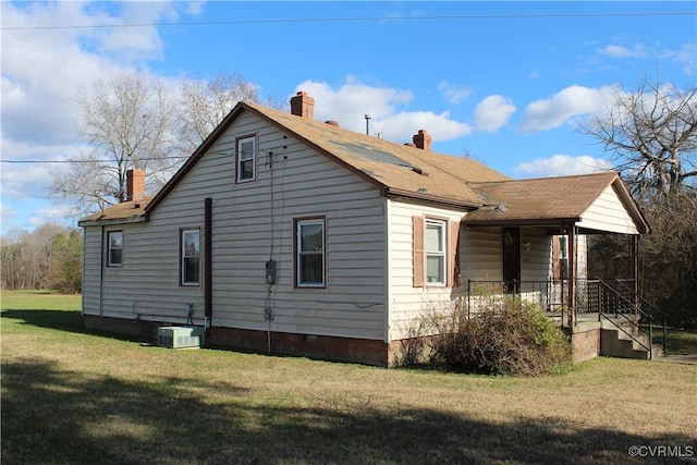 view of property exterior with covered porch, central AC, and a lawn