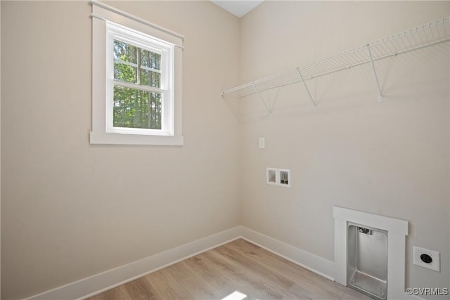 washroom featuring laundry area, baseboards, light wood-style flooring, washer hookup, and electric dryer hookup