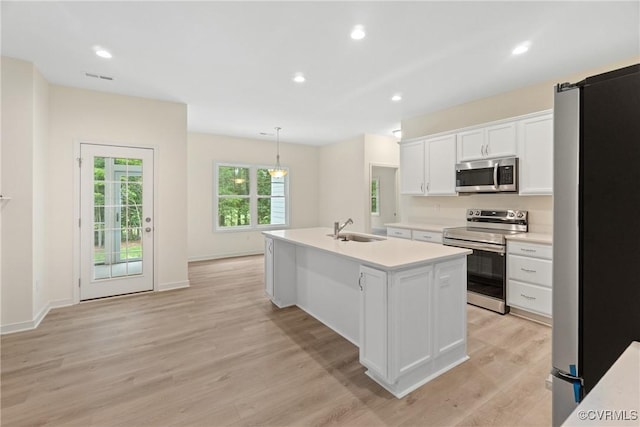 8355 Patrick Henry Blvd, Mechanicsville, VA 23116 - kitchen with stainless steel appliances, a sink, light countertops, light wood-style flooring, and an island with sink