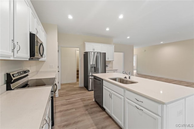 kitchen featuring stainless steel appliances, a sink, light countertops, and white cabinets