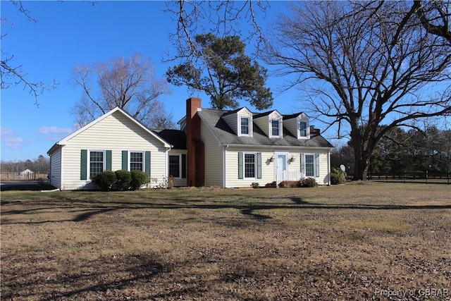 cape cod home with a front lawn