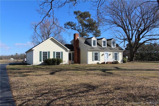 cape cod-style house with a front yard