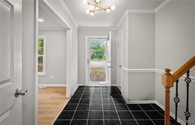 tiled foyer entrance with a wealth of natural light, crown molding, and a chandelier