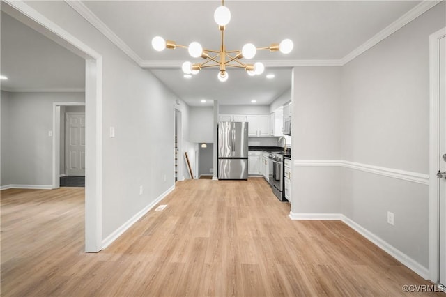 kitchen featuring appliances with stainless steel finishes, crown molding, a chandelier, and white cabinets