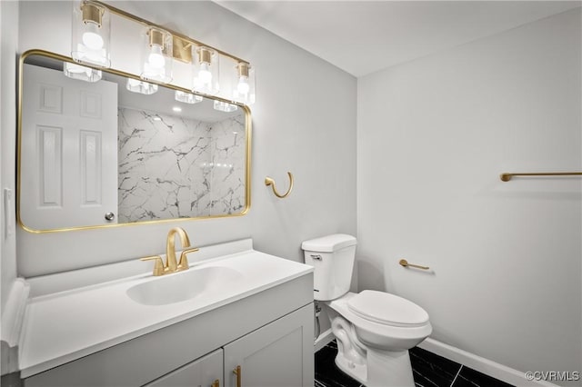 bathroom with toilet, vanity, and tile patterned flooring