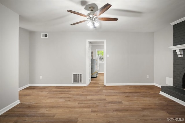 unfurnished living room with ceiling fan, light hardwood / wood-style floors, and a fireplace