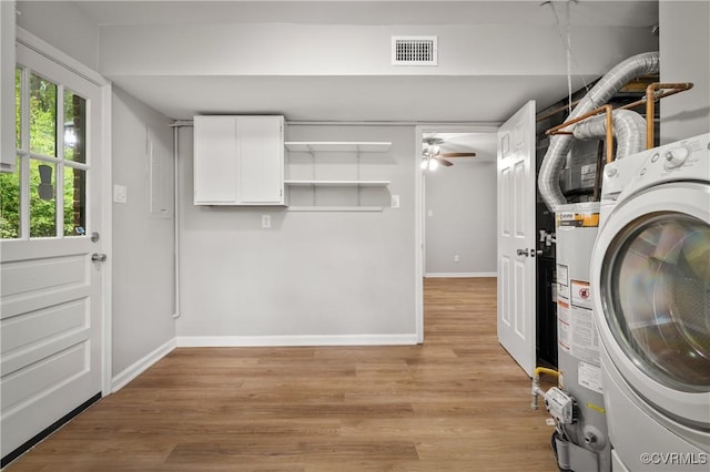 laundry area with washer / dryer, ceiling fan, light wood-type flooring, gas water heater, and cabinets